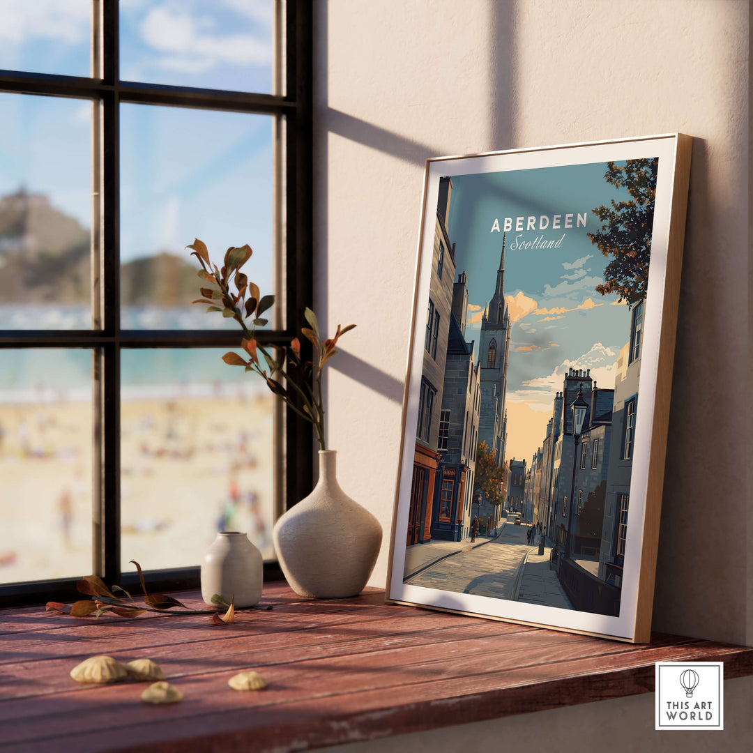 Aberdeen Print | Scottish Landmark Wall Art displayed on a table with a beautiful coastal view in the background.