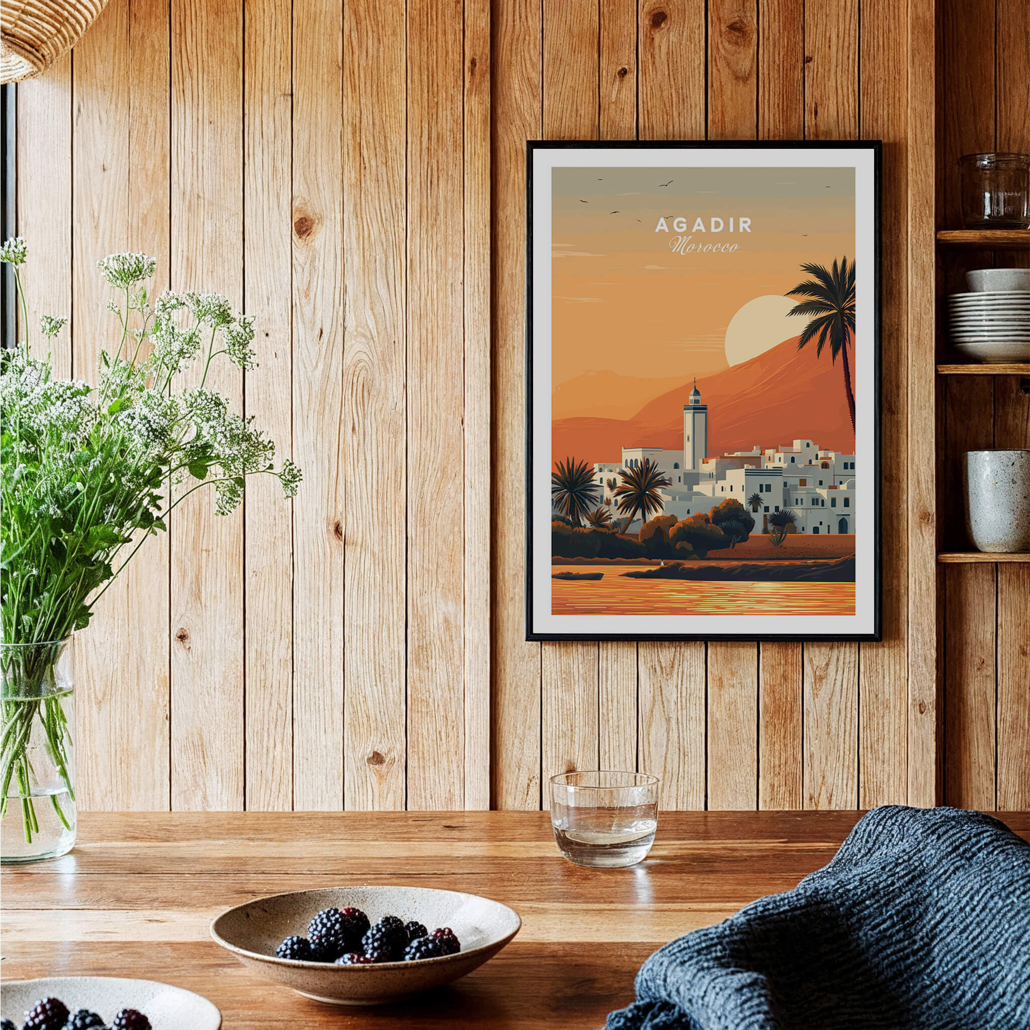Agadir Travel Poster – Moroccan Mosque and Desert Sunset Art displayed in a rustic setting with wooden decor.
