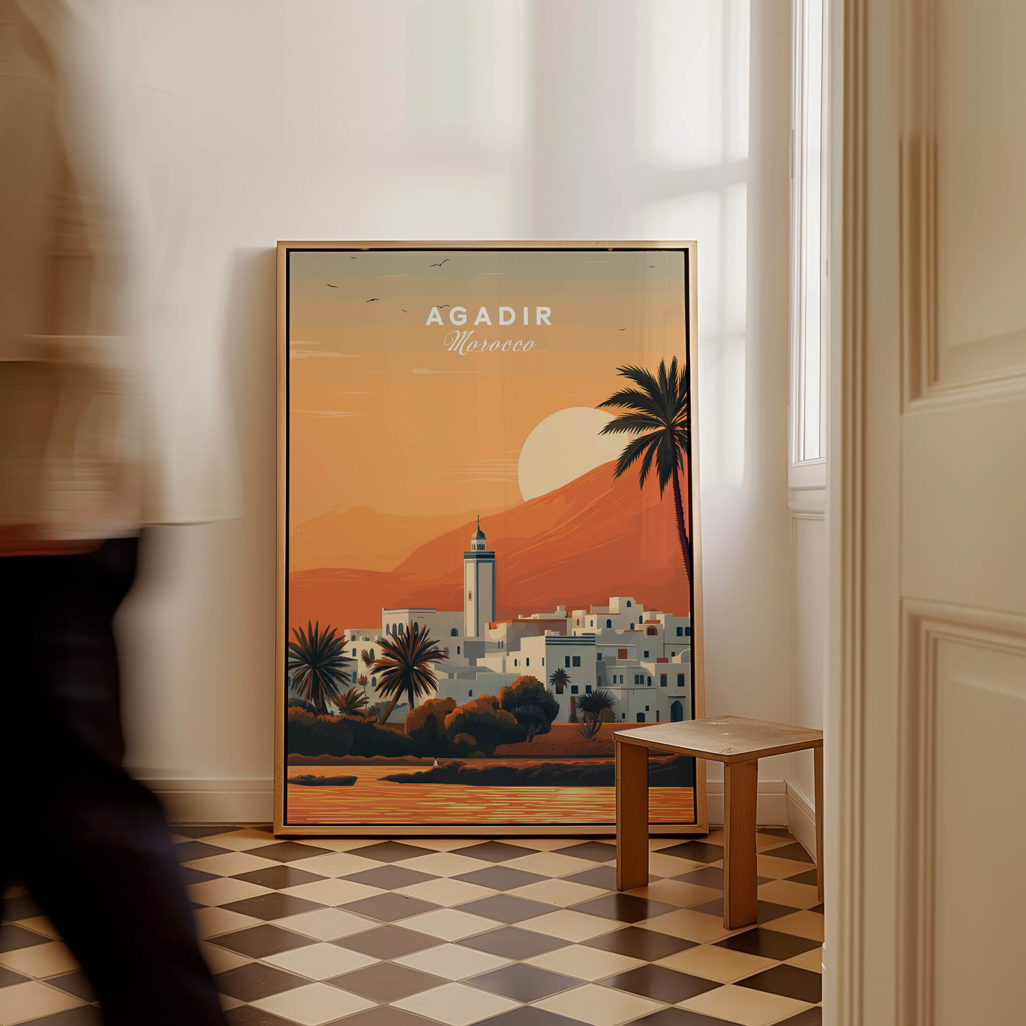 Agadir Travel Poster – Moroccan Mosque and Desert Sunset Art displayed in a stylish room with a checkered floor.