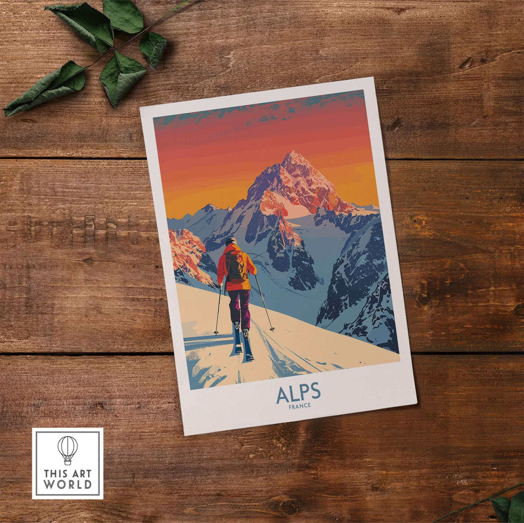 Vibrant Alps Poster France on wooden surface, featuring a skier against snowy peaks under a sunset sky, perfect for ski enthusiasts.