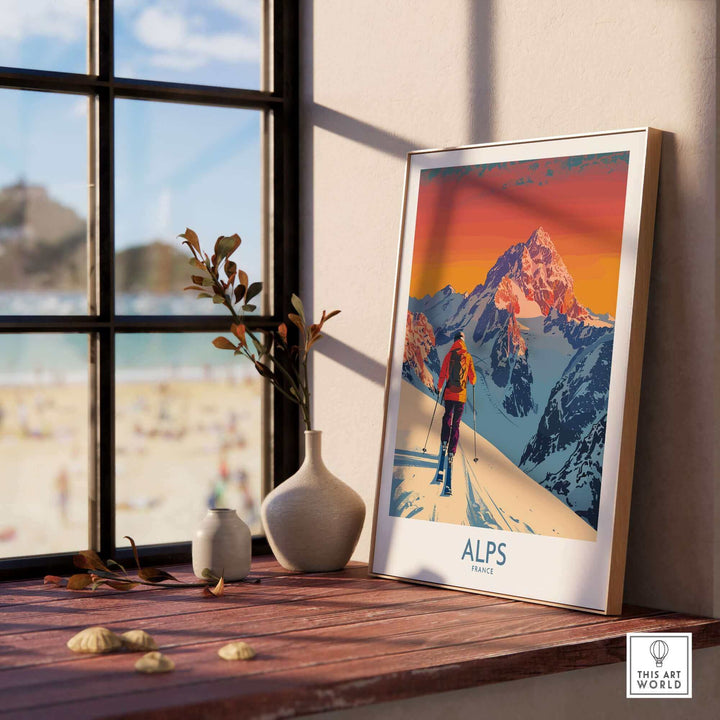 Vibrant Alps Poster France displayed on a wooden shelf by a sunlit window, capturing the scenic snowy peaks and adventurous ski theme.