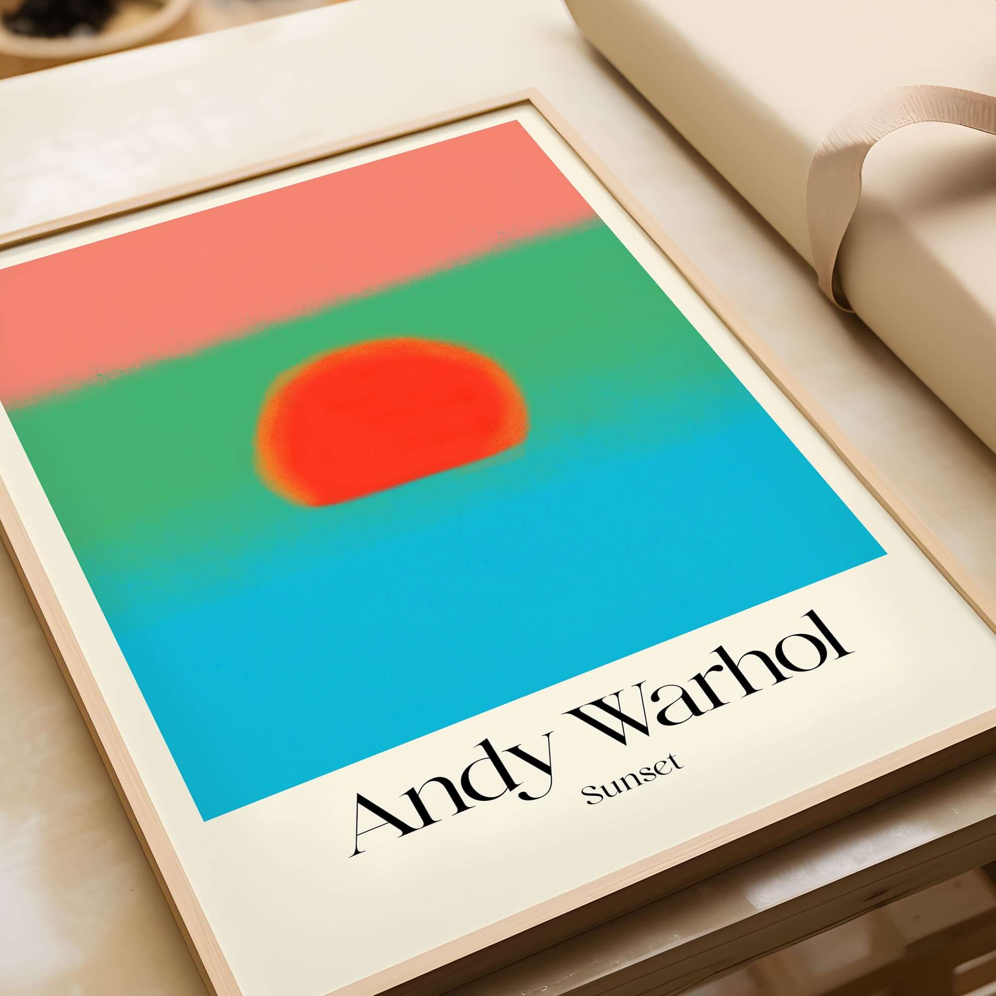Andy Warhol Sunset Coral Green Blue Pop Art Poster Abstract Wall Art Print Modern displayed on a table.