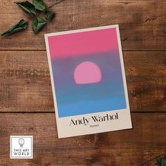 Andy Warhol Sunset Pink Blue Pop Art Poster Abstract Screenprint Wall Art Print displayed on wooden table.