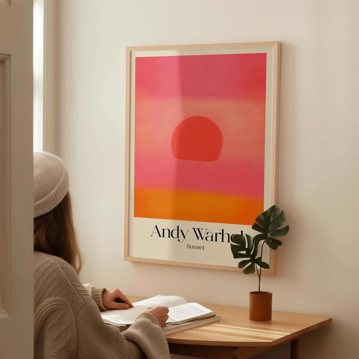 Andy Warhol Sunset Pink Orange Pop Art Print Modern Abstract Poster Wall Art displayed in a cozy setting with a person reading.