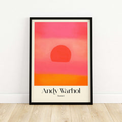 Andy Warhol Sunset Pink Orange Pop Art Print Modern Abstract Poster Wall Art displayed in a black frame on a wooden floor.