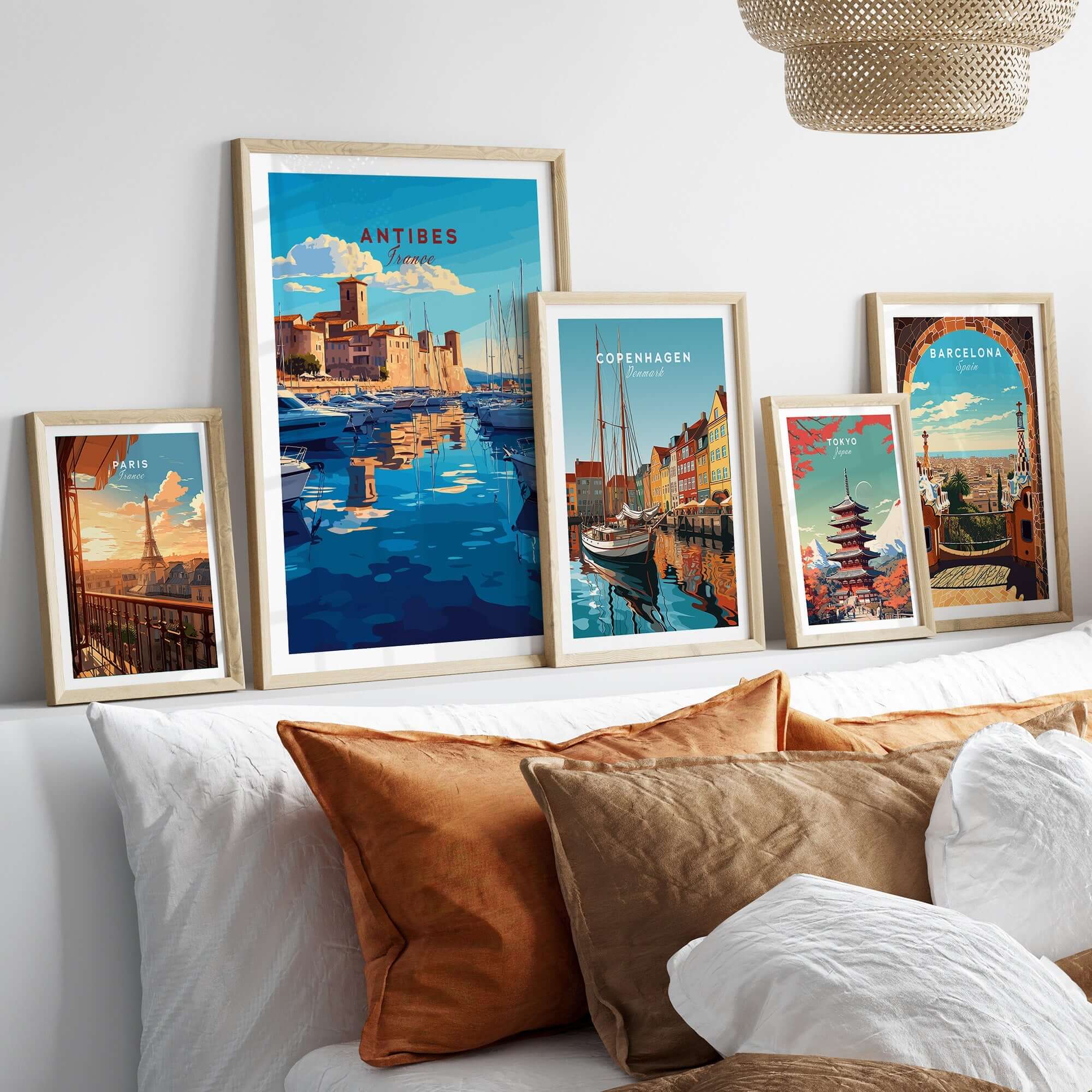 Antibes Print France displayed among framed city prints on a stylish modern bed.