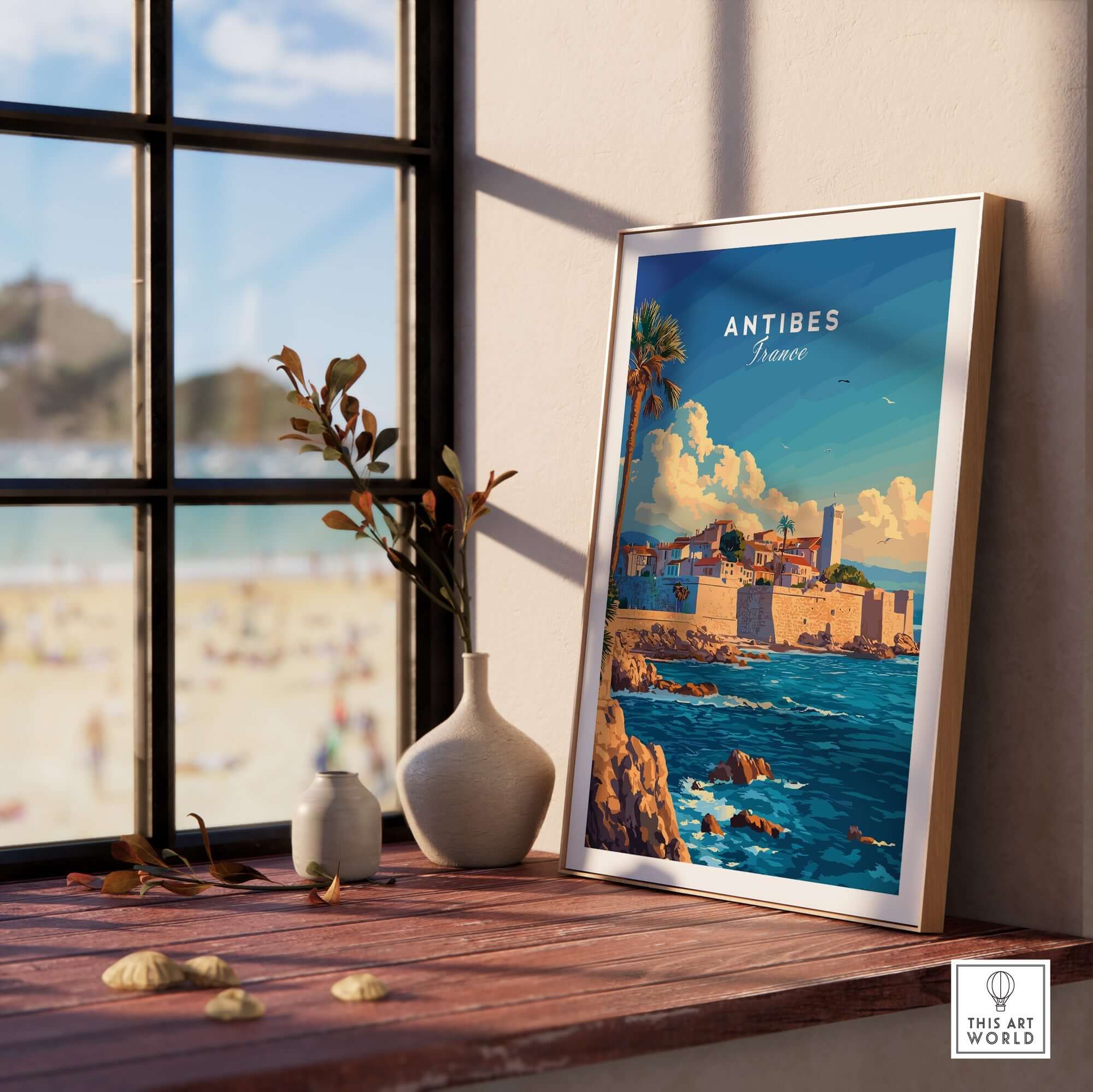Antibes Wall Art Poster framed on a table by a window, showcasing a scenic view of Antibes, France.