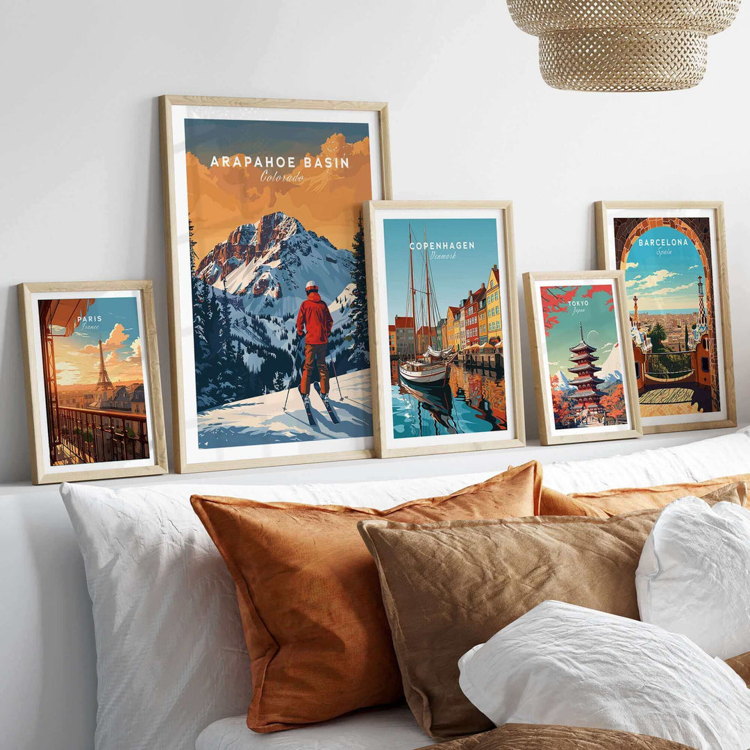 Arapahoe Basin travel poster among framed city posters on a stylish bed with decorative pillows. Perfect for ski and travel enthusiasts.