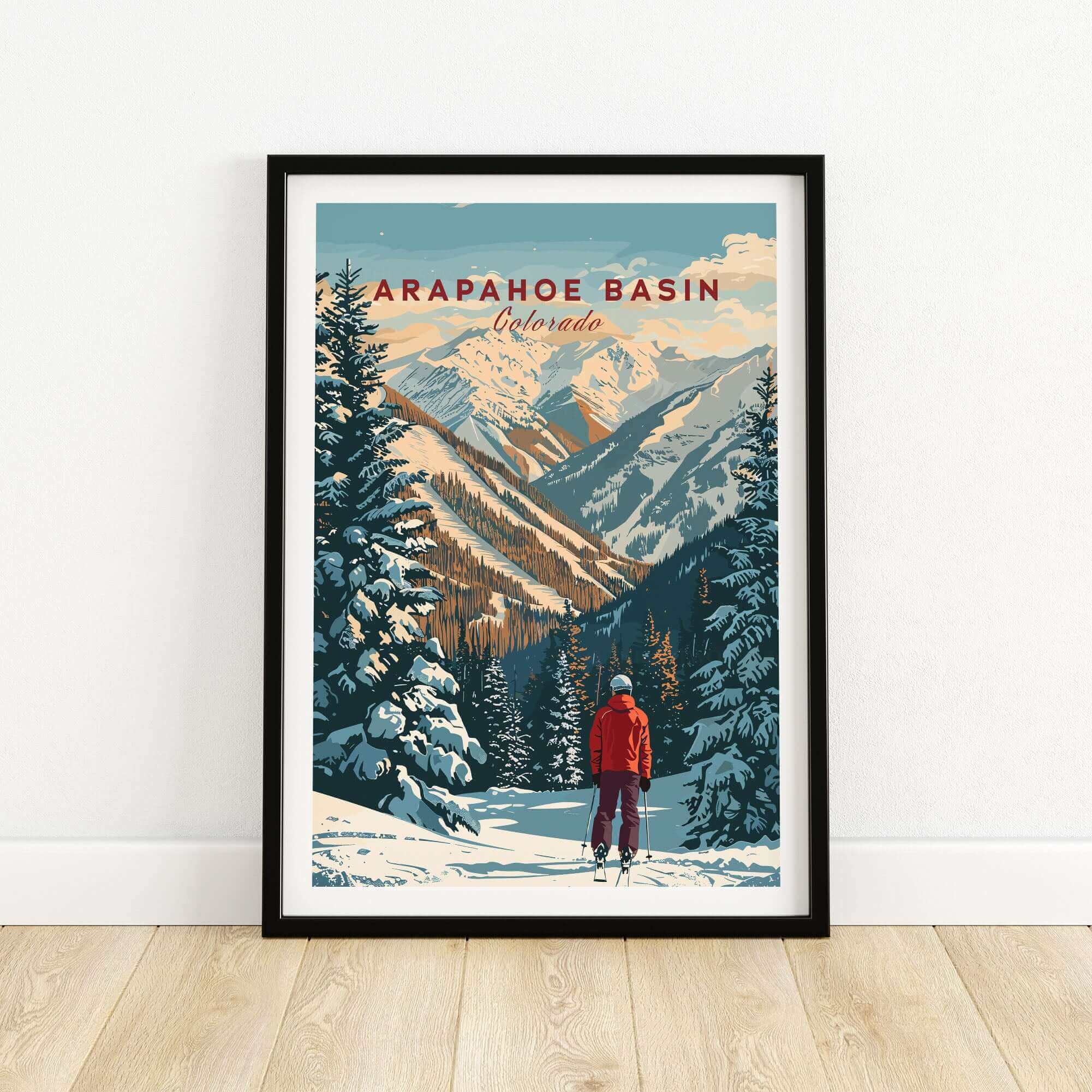 Arapahoe Basin wall art with skier and mountain landscape in black frame on wooden floor.