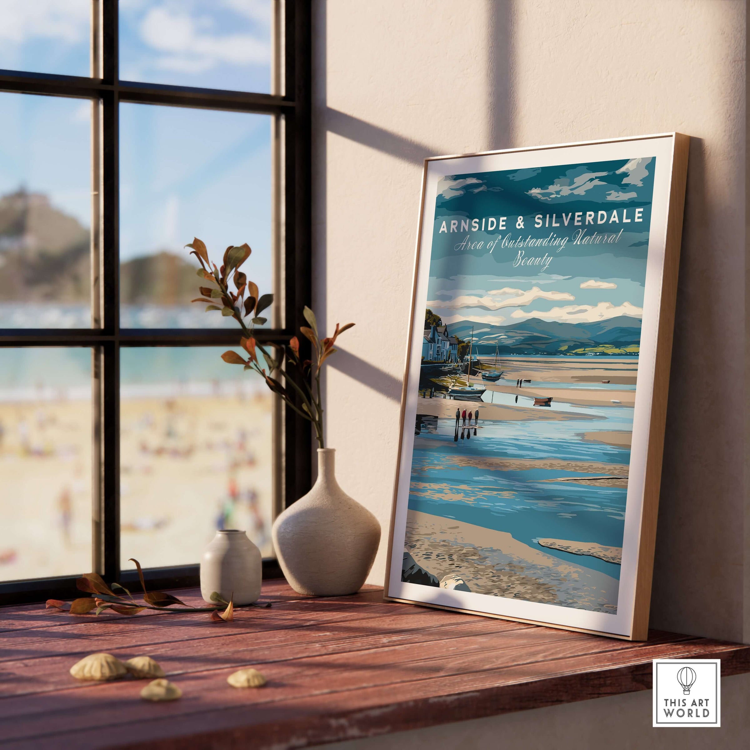 Arnside and Silverdale AONB Wall Art Poster displayed on a desk with a beach view in the background.