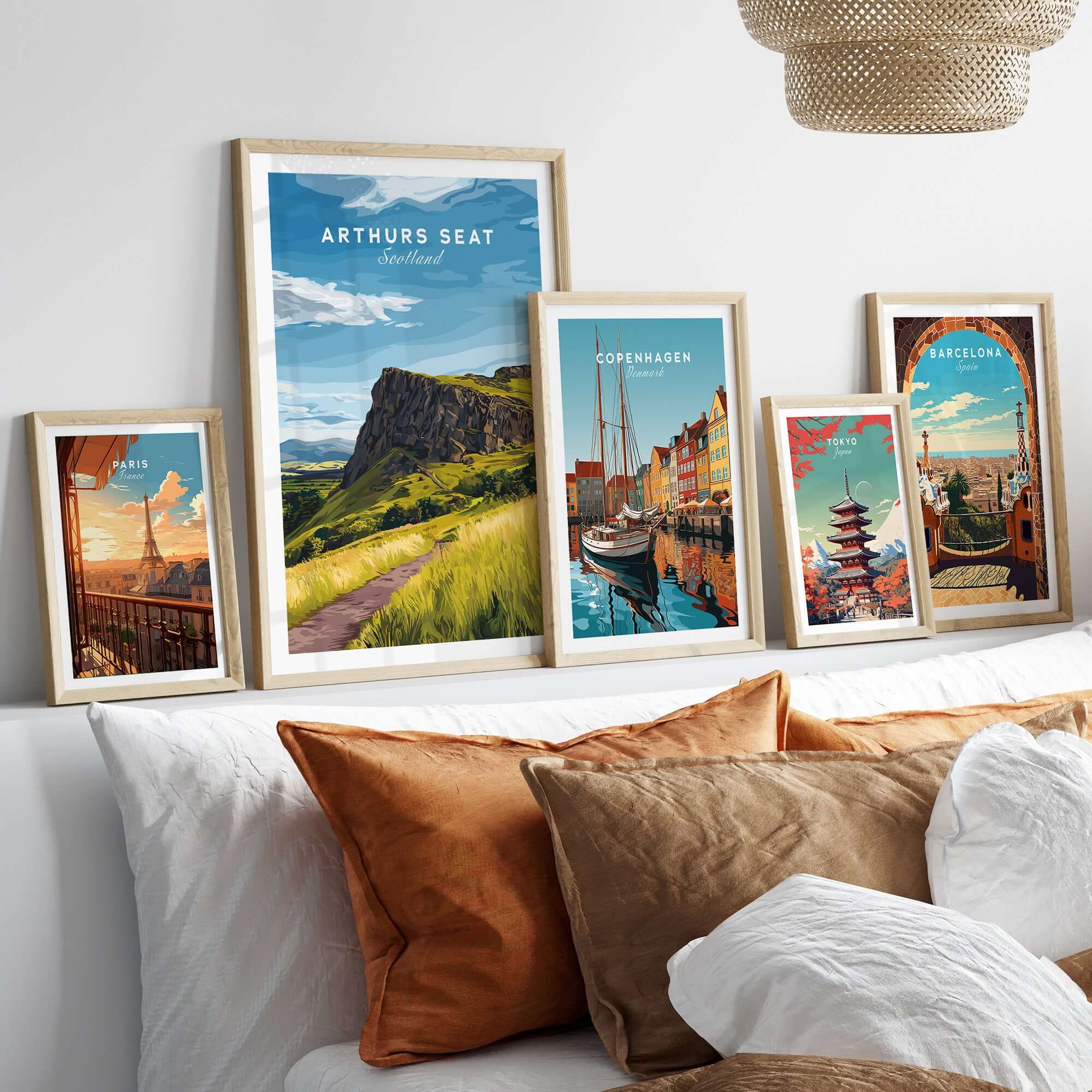 Arthurs Seat Scotland Travel Print displayed among other travel prints on a cozy sofa.