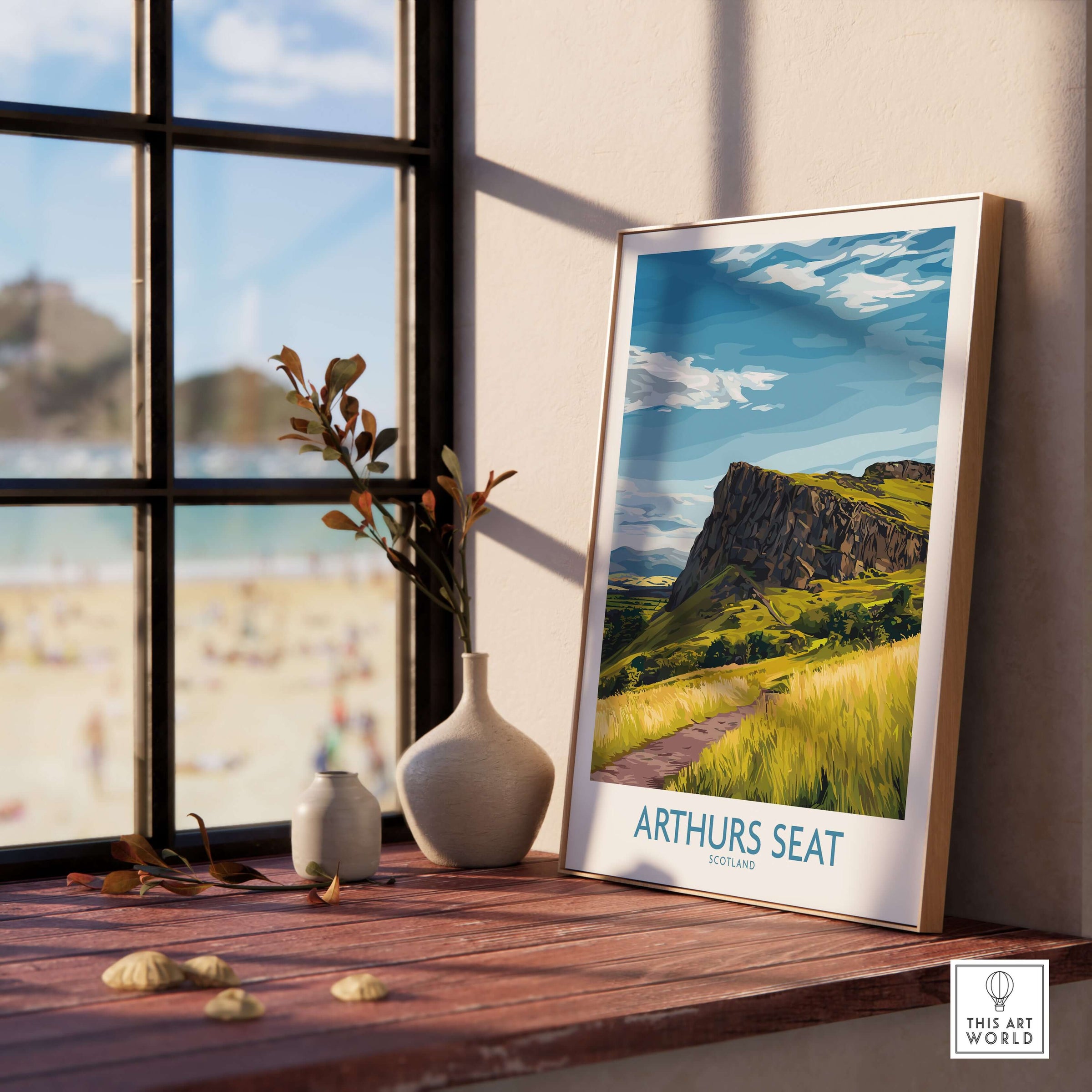 Arthurs Seat Scotland Wall Art Print displayed on a wooden table by a window, showcasing the scenic landscape.