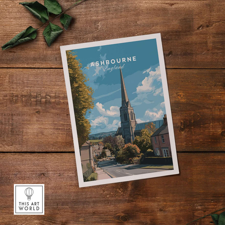 Ashbourne art print showcasing English countryside scene with church steeple, minimalist travel poster on wooden background.