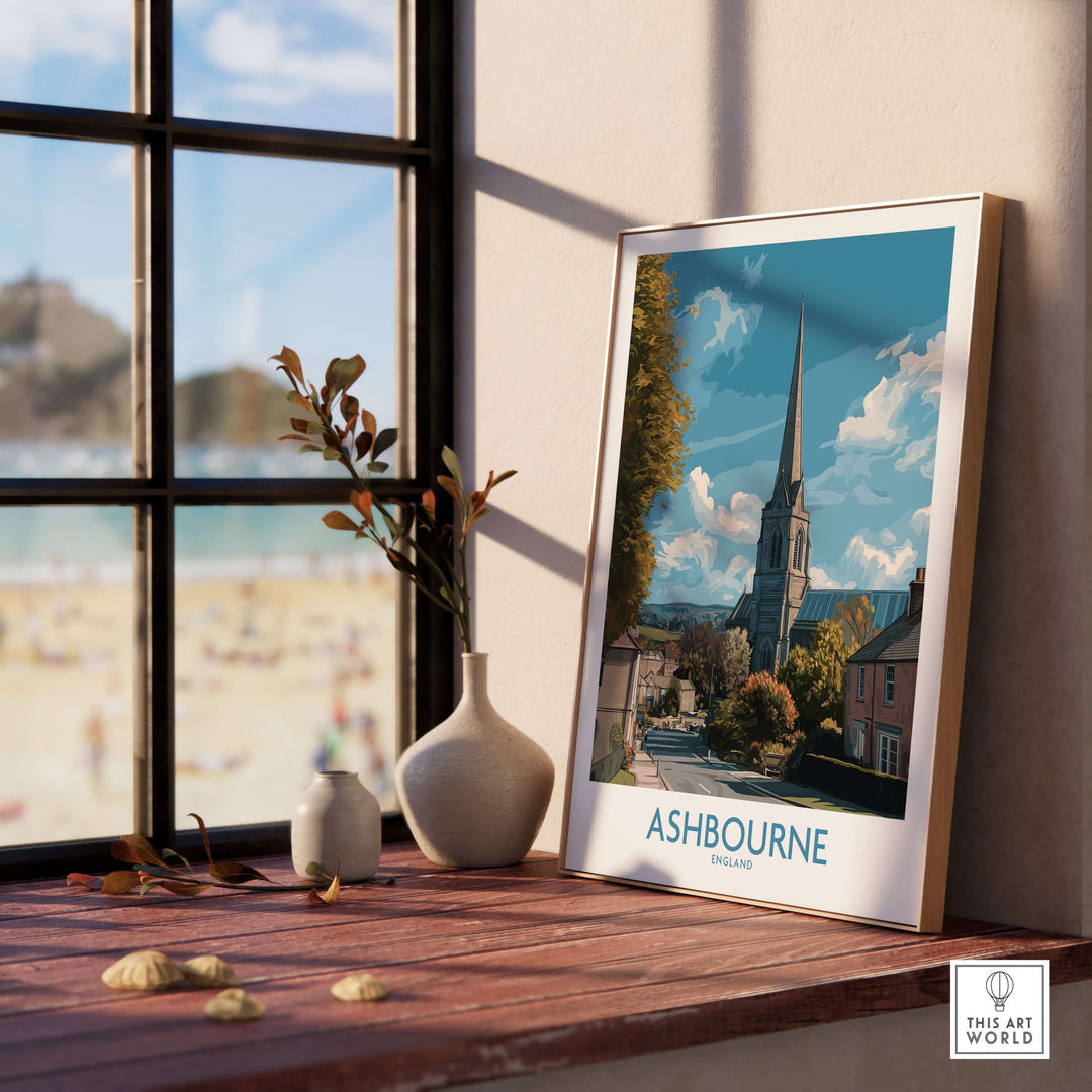 Ashbourne poster showcasing a picturesque UK village scene, displayed elegantly on a windowsill.