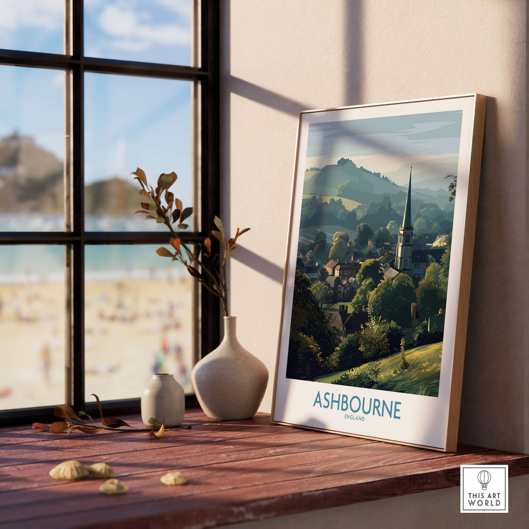 Ashbourne travel poster showcasing Derbyshire Peak District scenery, framed on a windowsill with decorative vases.