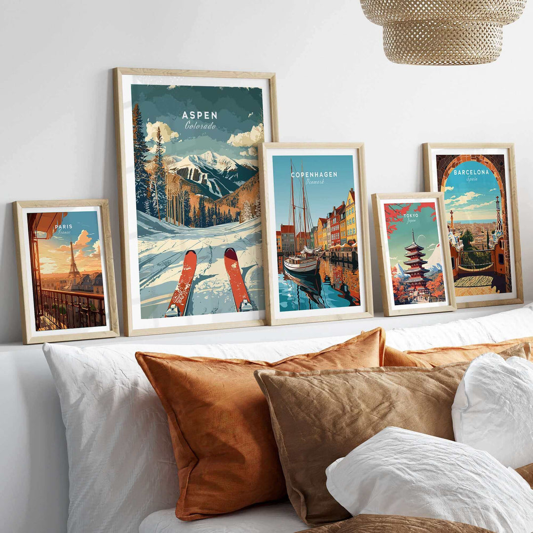 Aspen travel poster among framed artwork on a modern bed with cozy pillows showcasing scenic destinations.