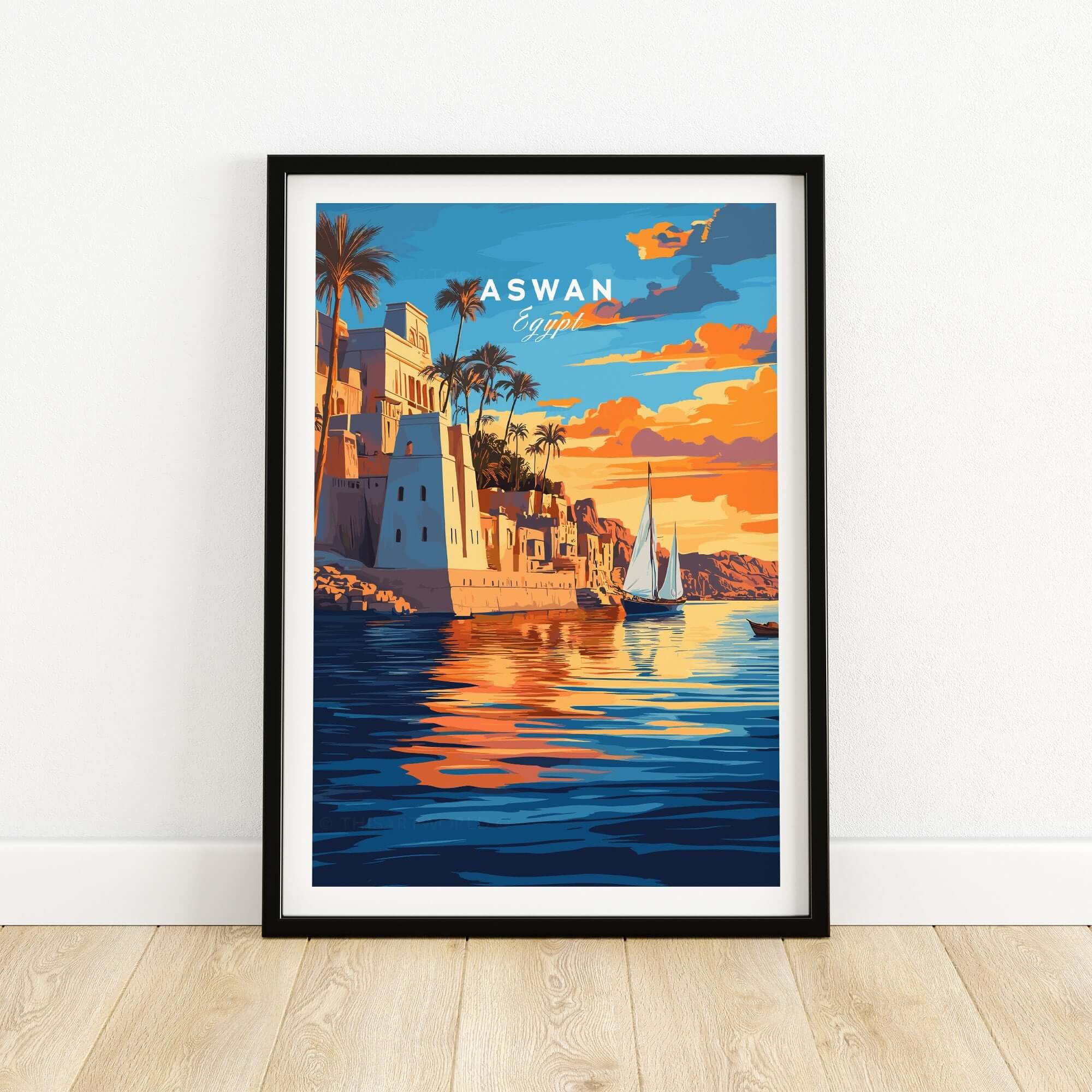 Aswan Travel Print showcasing vibrant sunset over the Nile River, featuring picturesque buildings and sailboats in Aswan, Egypt.