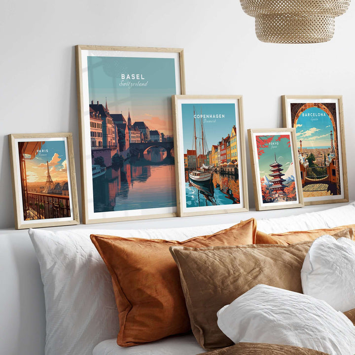 Collection of European cityscape wall art prints featuring Basel, Copenhagen, and Barcelona on a cozy sofa.