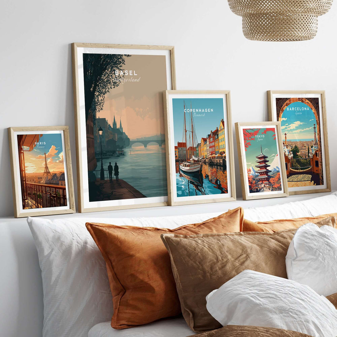 Framed posters of Basel, Copenhagen, and Barcelona cityscapes displayed on a cozy couch.
