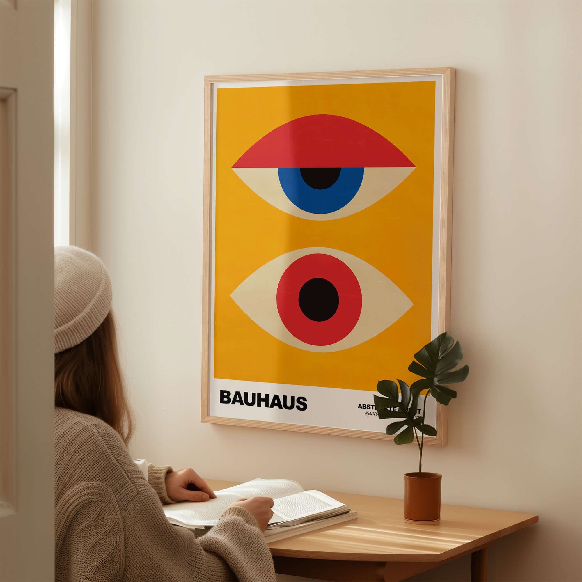 Bauhaus Exhibition Prints - Abstract Eyes Poster Geometric Orange Red Blue Art displayed on wall with person reading.