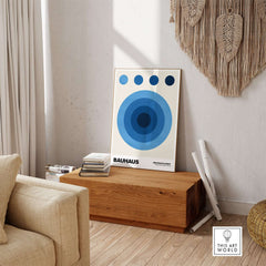 Bauhaus Exhibition Prints - Abstract Blue Circles Poster Geometric Design displayed in a stylish interior with cream and wood elements.