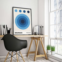Bauhaus Exhibition Prints - Abstract Blue Circles Poster Geometric Design displayed in a modern workspace with a black chair.