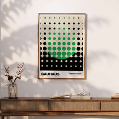 Bauhaus Exhibition Prints - Abstract Circle Pattern Art Print Green Black Dot Gradient framed on a wall with a wooden table.