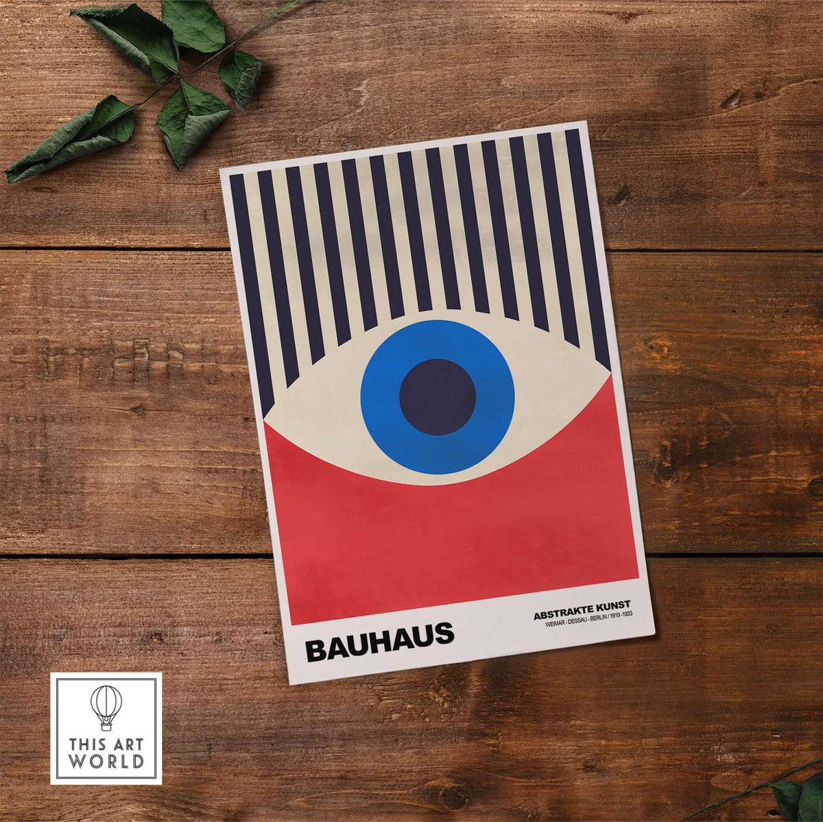 Bauhaus Exhibition Prints - Abstract Eye Art Print Geometric Red Blue Design on wooden surface with green leaves.