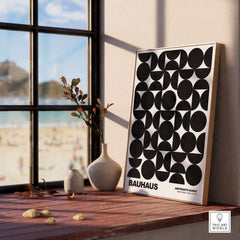 Bauhaus Exhibition Prints - Geometric Circle Shapes Art Print Black White Pattern displayed on a windowsill with beach view.