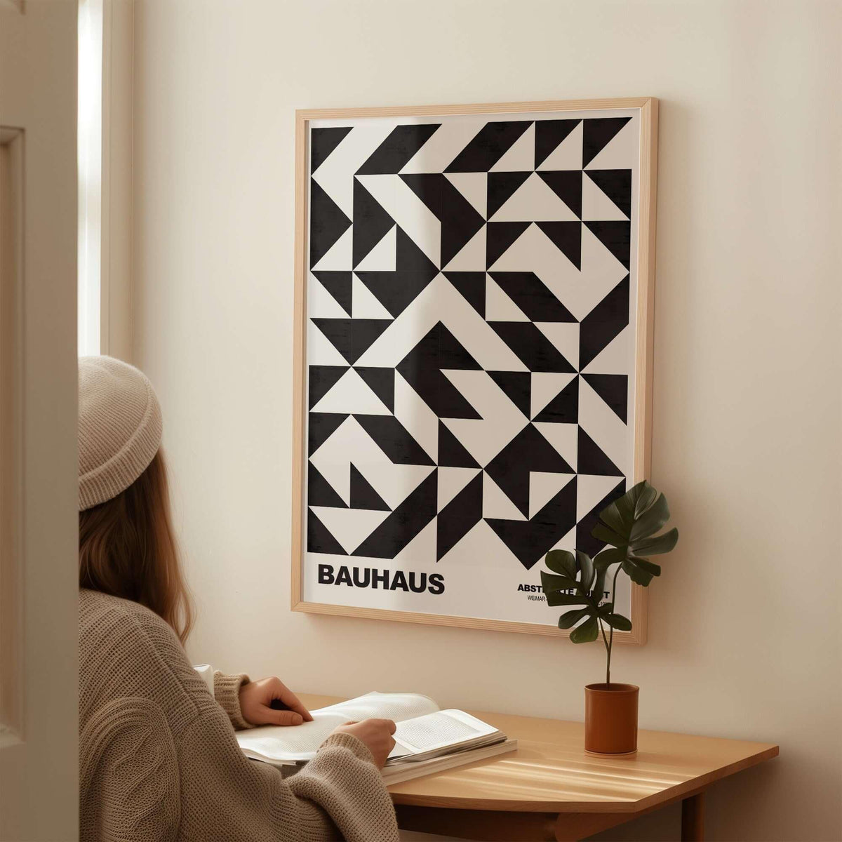 Bauhaus Exhibition Prints - Geometric Triangle Pattern Poster Black White Abstract displayed on wall near a woman reading at a desk.