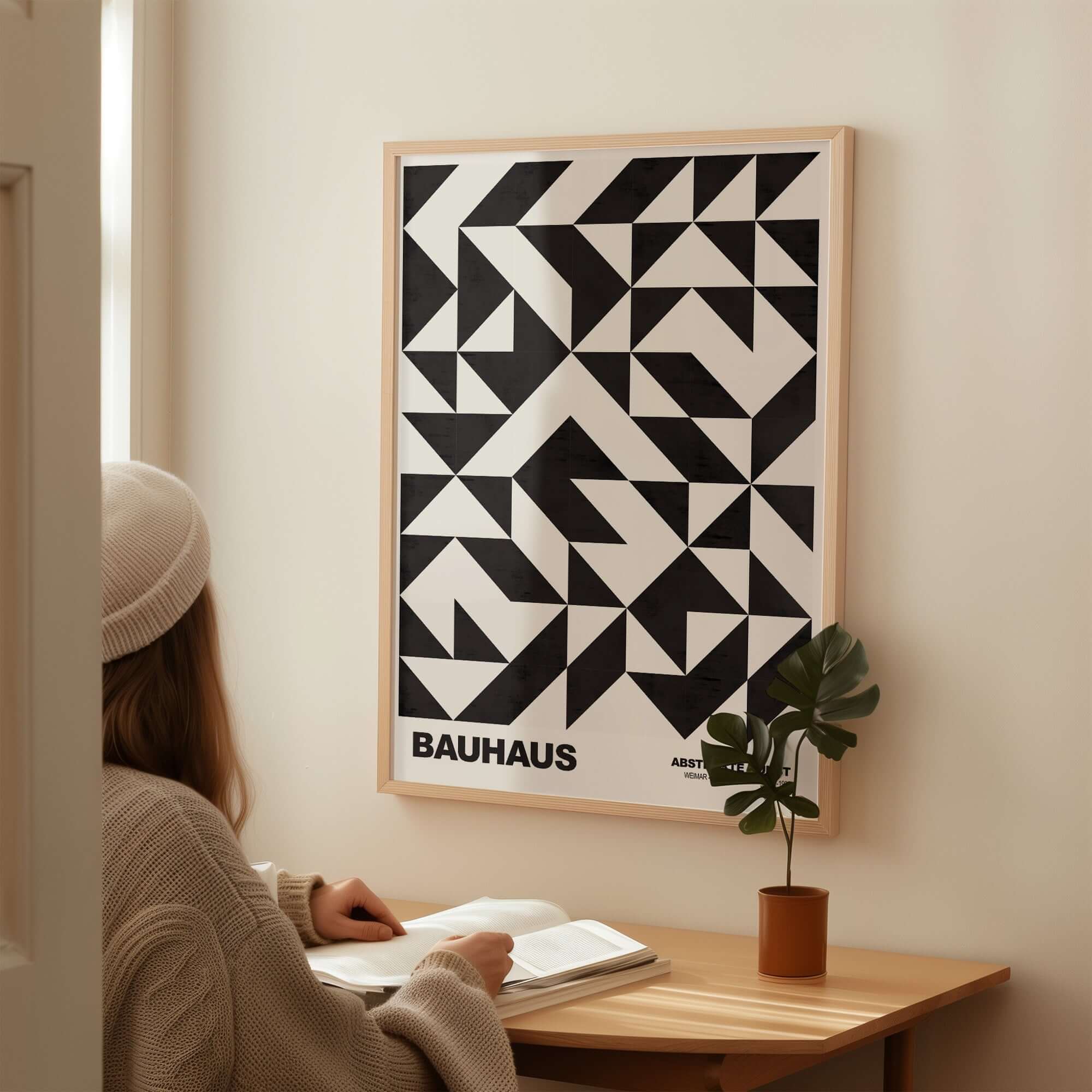 Bauhaus Exhibition Prints - Geometric Triangle Pattern Poster Black White Abstract displayed on wall near a woman reading at a desk.