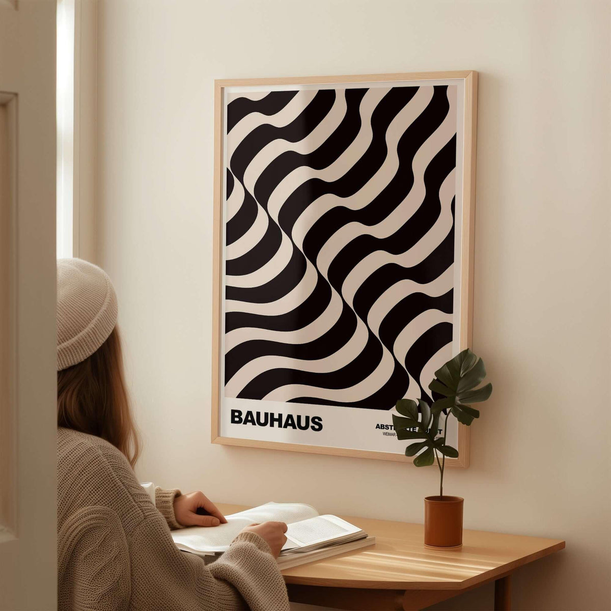 Bauhaus Exhibition Prints - Thick Undulating Waves Poster Black Cream Abstract Art displayed on a wall next to a person reading.