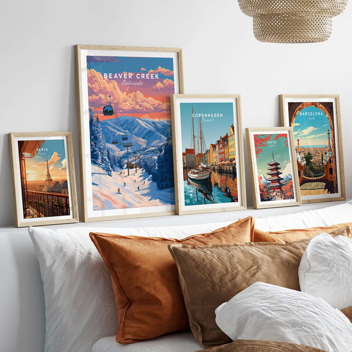 Framed posters of Beaver Creek ski resort and various cities on a cozy bed, showcasing colorful wall art.