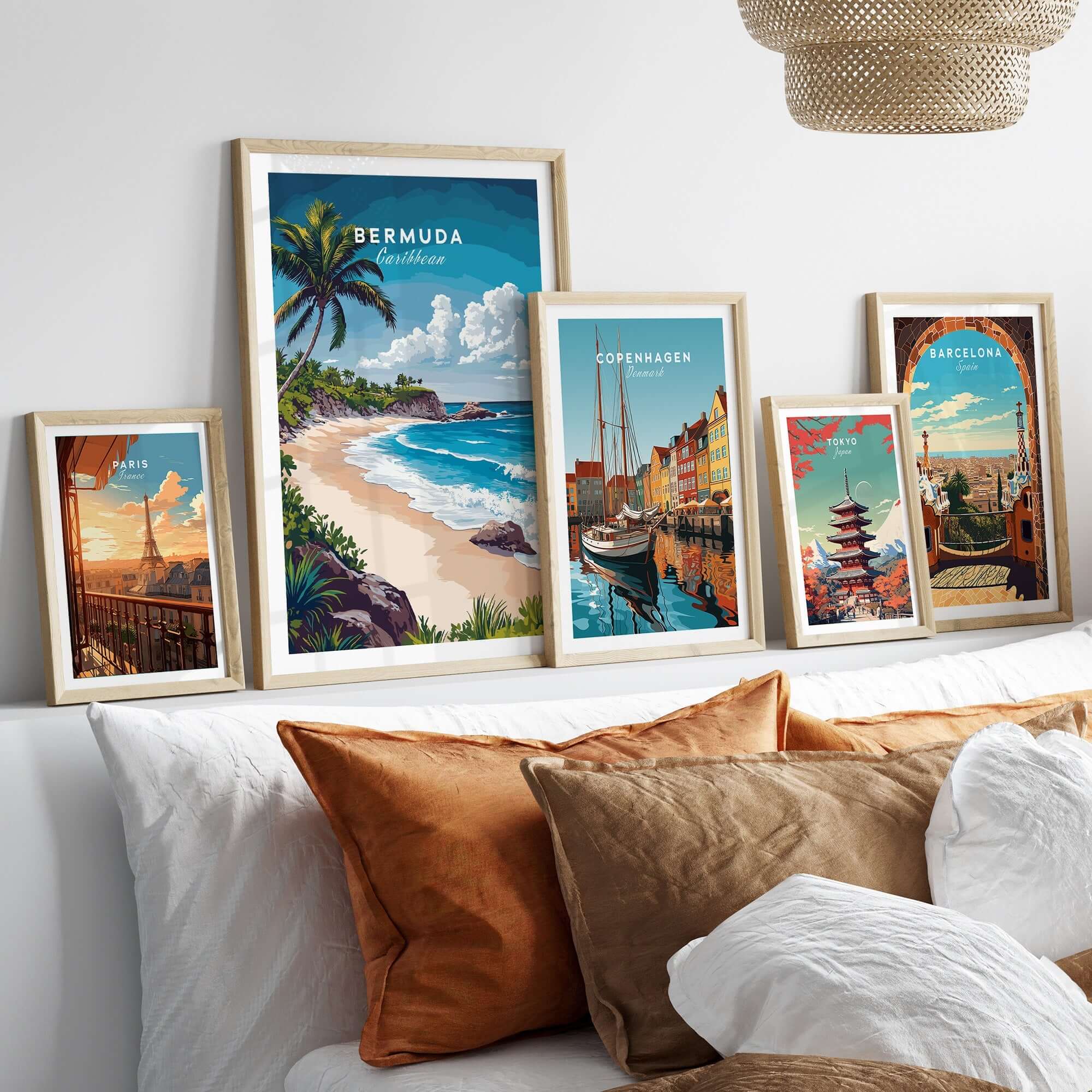 Bermuda Print featuring a tropical beach scene among framed travel posters on a stylish sofa.