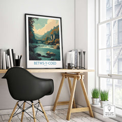 Betws-y-Coed Poster Wales Art Print displayed on a desk in a stylish home office setting.