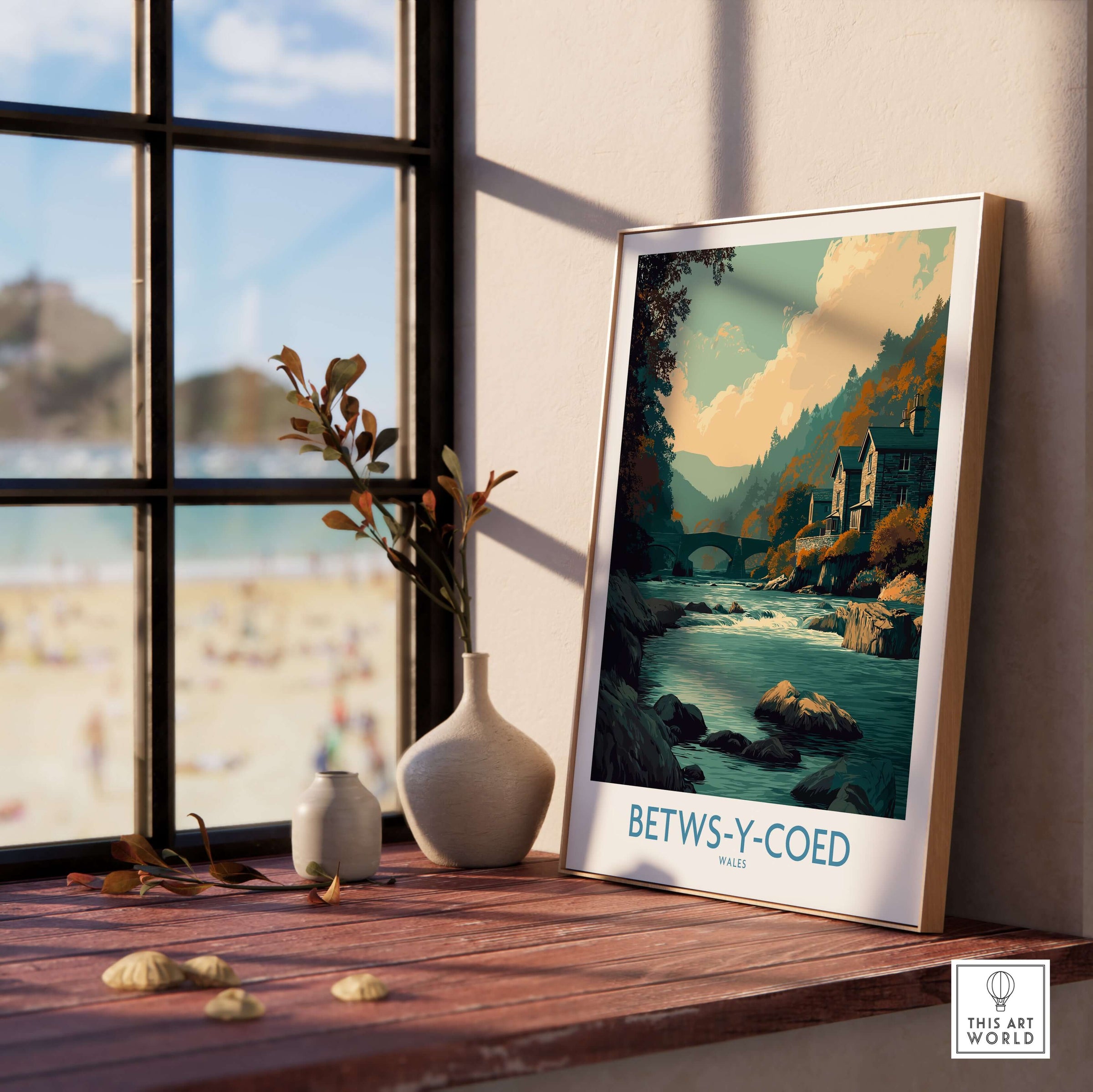 Betws-y-Coed Poster Wales Art Print displayed in a cozy interior setting with a river and mountains in the background.