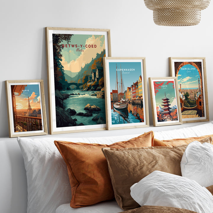 Framed Betws-y-Coed travel print amid other travel artwork showcasing vibrant landscapes and cityscapes.