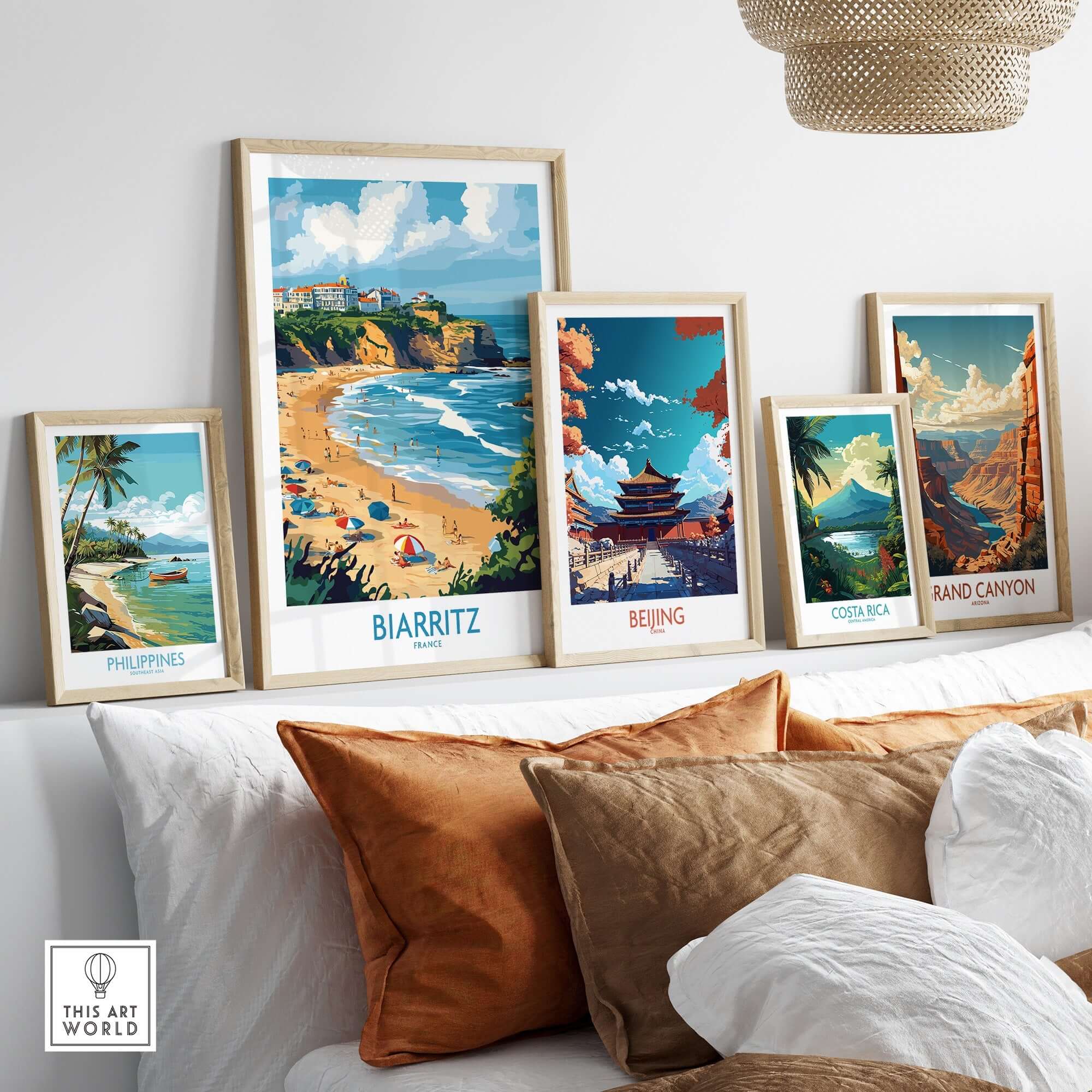 Biarritz Travel Poster displayed among other travel art prints on a cozy couch, showcasing coastal beauty.