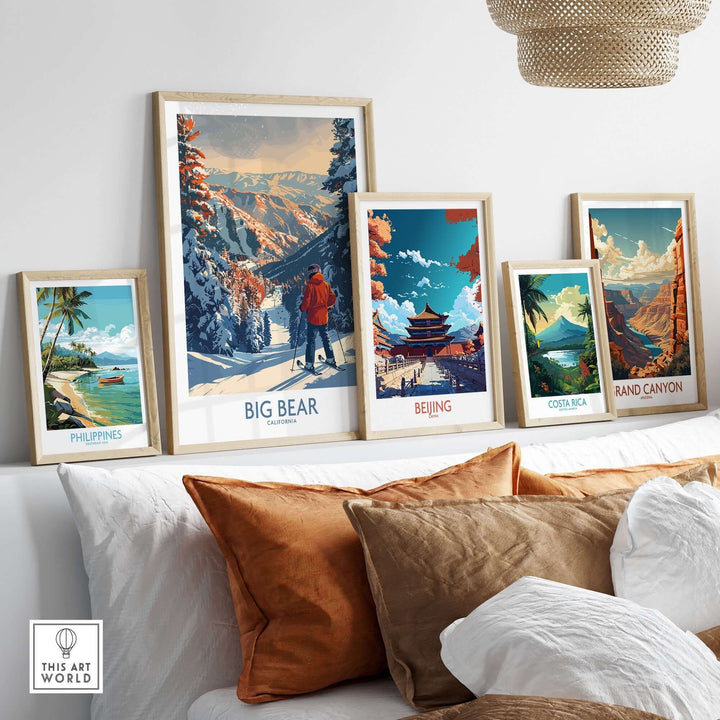 Framed travel prints including Big Bear, Beijing, Costa Rica, and Grand Canyon displayed on a shelf above a cozy couch.