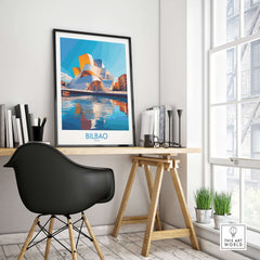 Bilbao Poster Spain displayed on a home office desk with view of modern architecture and sunlight.