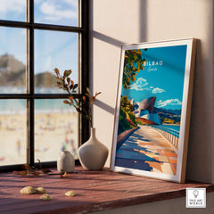 Bilbao Print poster displayed on a table with a view of the beach, adding vibrant decor to the room.