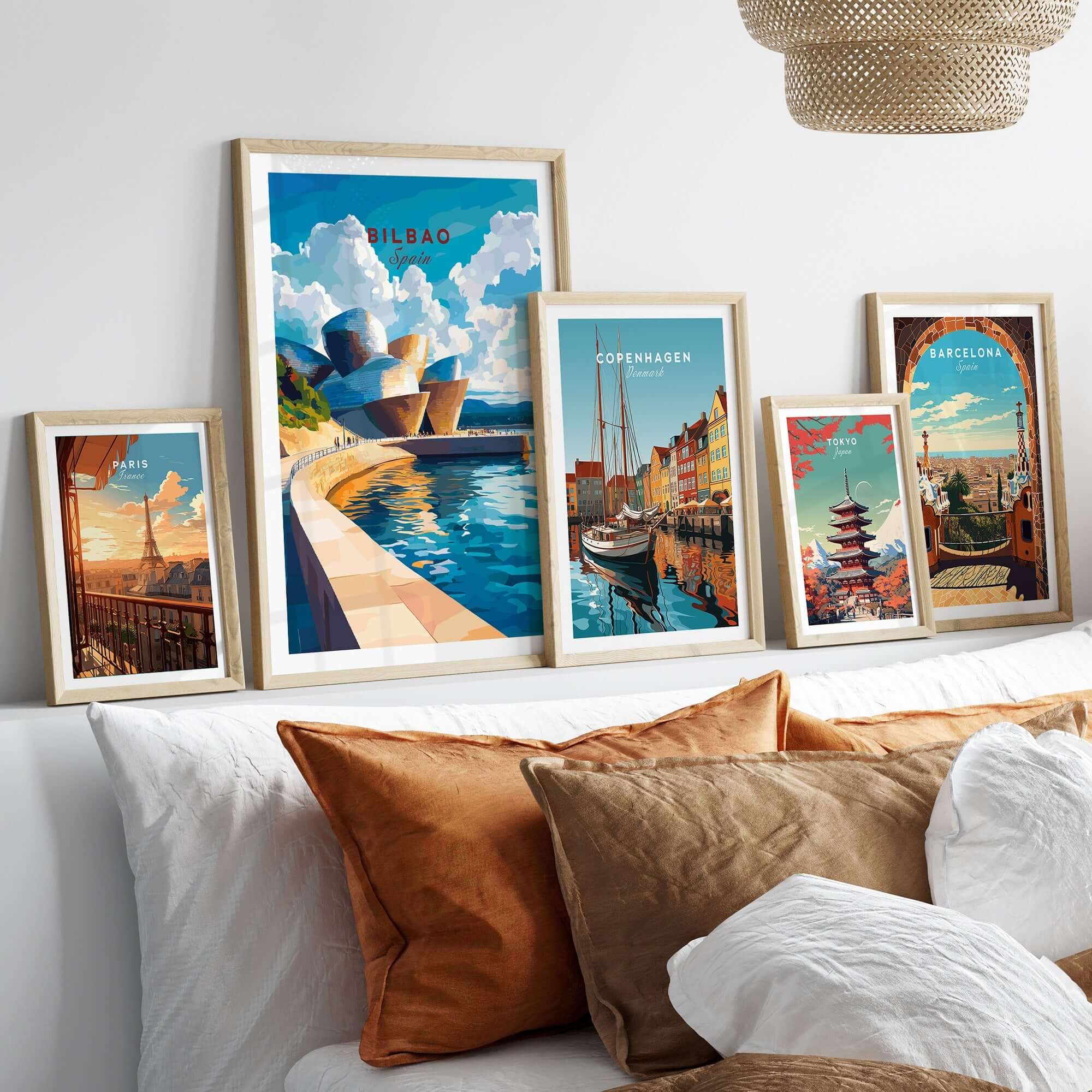 Bilbao Wall Art displayed in stylish frames above a bed, featuring colorful cityscapes and iconic architecture.