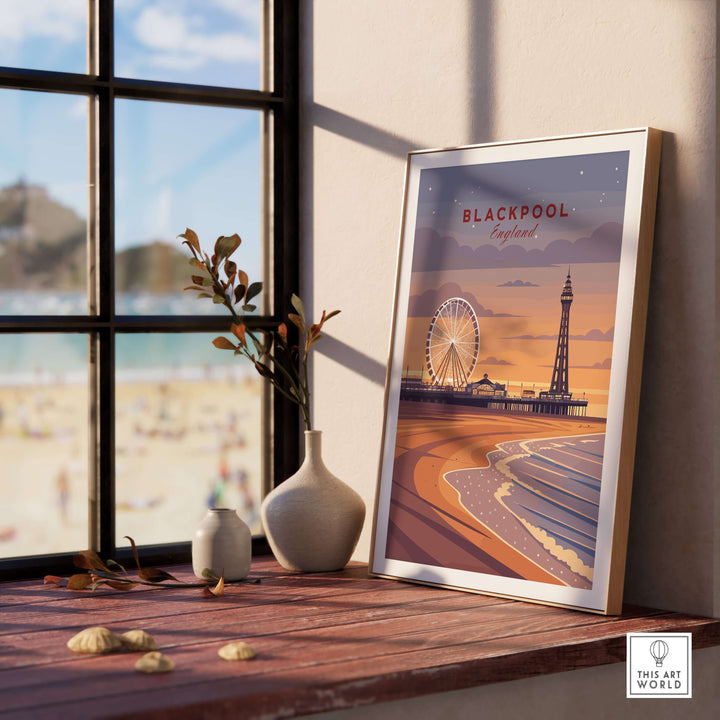 Blackpool Print | UK Coastal Wall Decor displayed on a wooden shelf with a beach view in the background.