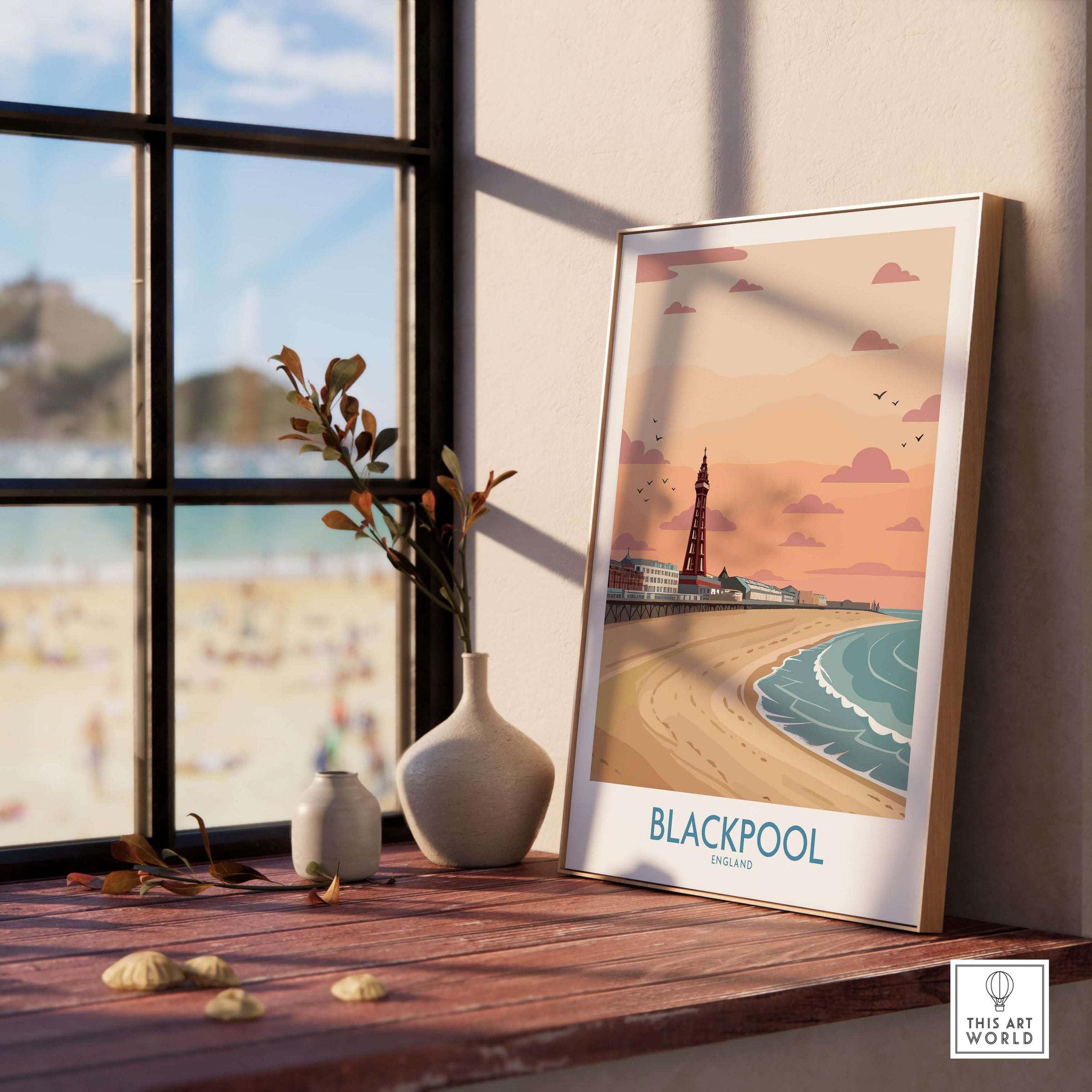 Blackpool Sunset Tower Beach Art Print | Pink Sky UK Coastal Poster displayed on a shelf by a window with beach view.
