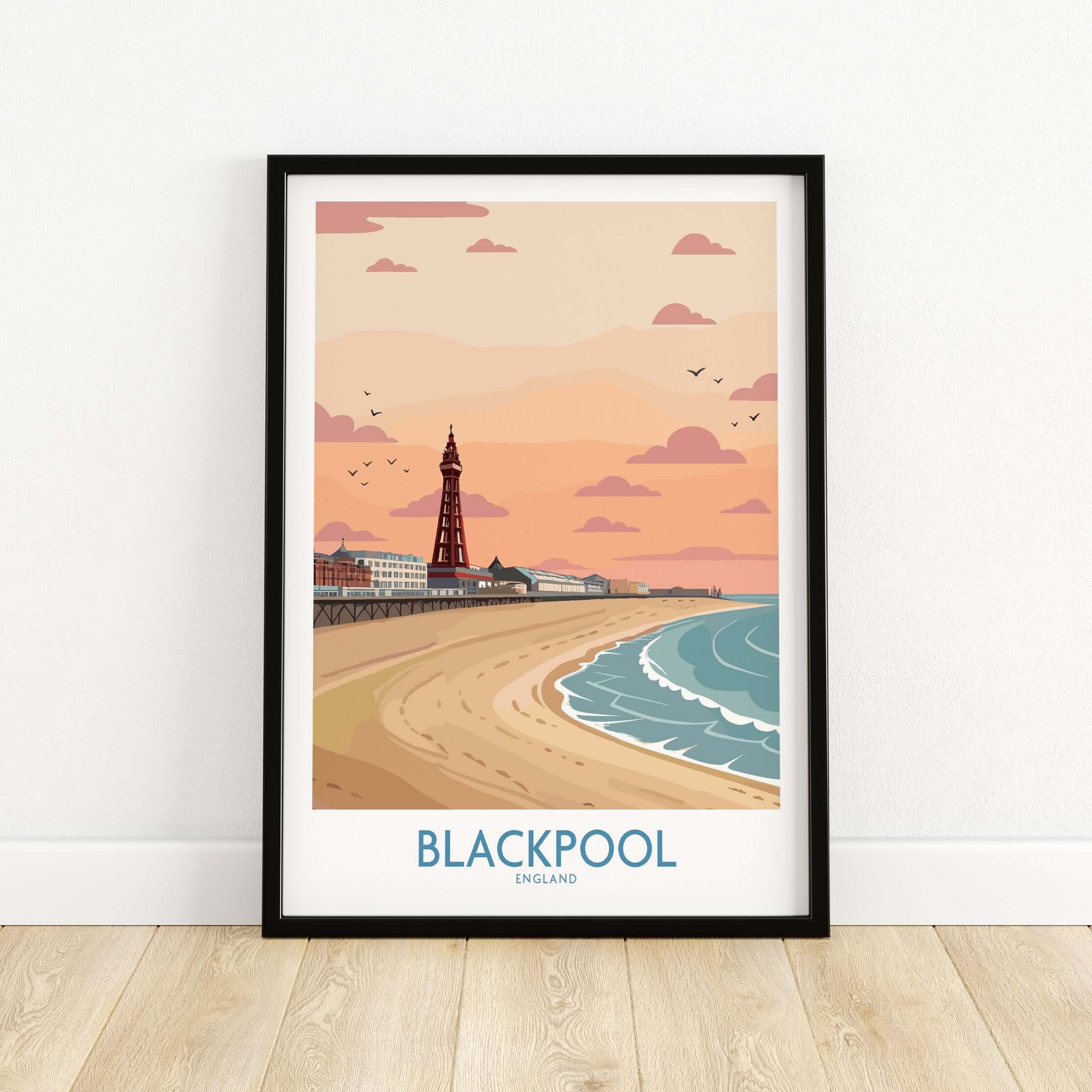 Blackpool Sunset Tower Beach Art Print | Pink Sky UK Coastal Poster in a stylish frame on a wooden floor