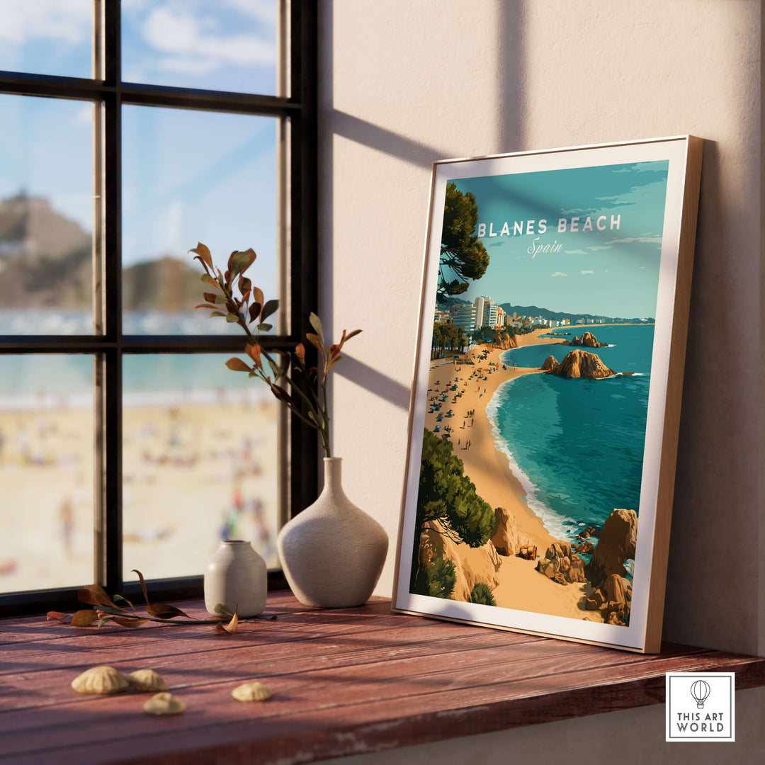 Blanes Beach Spain travel poster print displayed on a wooden table, perfect coastal wall art decor for sunny interiors.