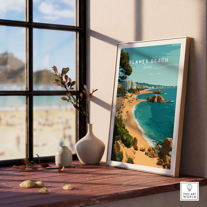 Blanes Beach Spain travel poster print displayed on a wooden table, perfect coastal wall art decor for sunny interiors.