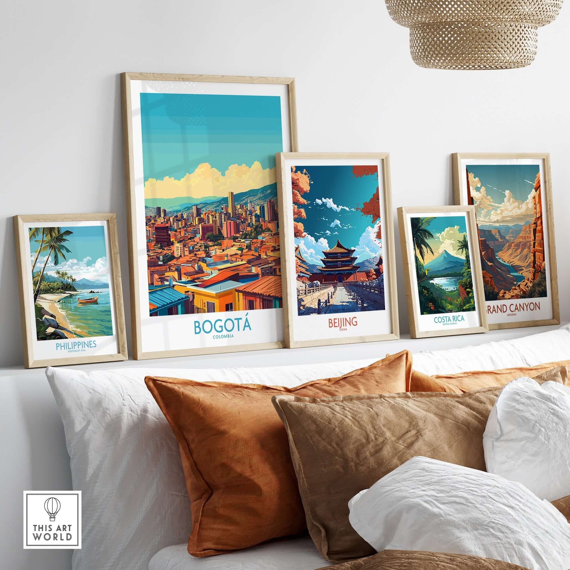 A cozy display of framed travel posters including a vibrant Bogota Poster on a sofa.