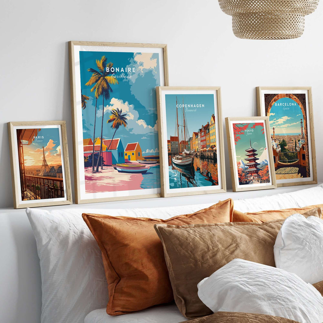 Framed tropical art prints featuring Bonaire, Copenhagen, Barcelona on a stylish shelf above plush pillows.