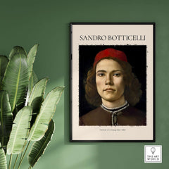 Botticelli Portrait Young Man Red Hat 1483 Art Print Renaissance Florentine Poster displayed on a green wall.